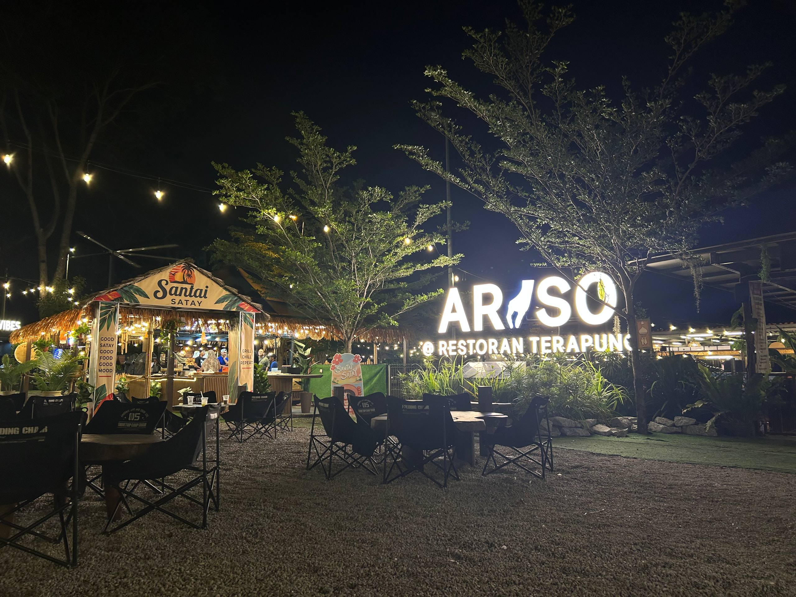 Araso courtyard and illuminated restaurant sign at night
